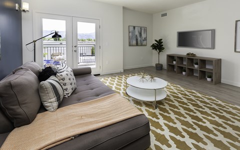 A living room with a grey couch and a white coffee table.