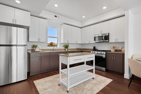 a kitchen with white cabinets and a island in the middle