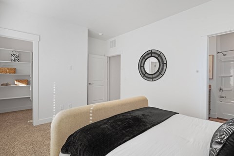 a bedroom with a large bed and a mirror on the wall