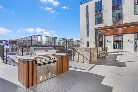 A modern outdoor kitchen with a grill and sink.