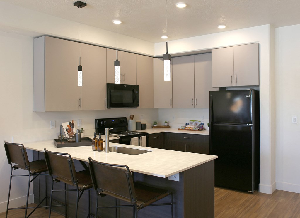 a kitchen with a large island and a black refrigerator