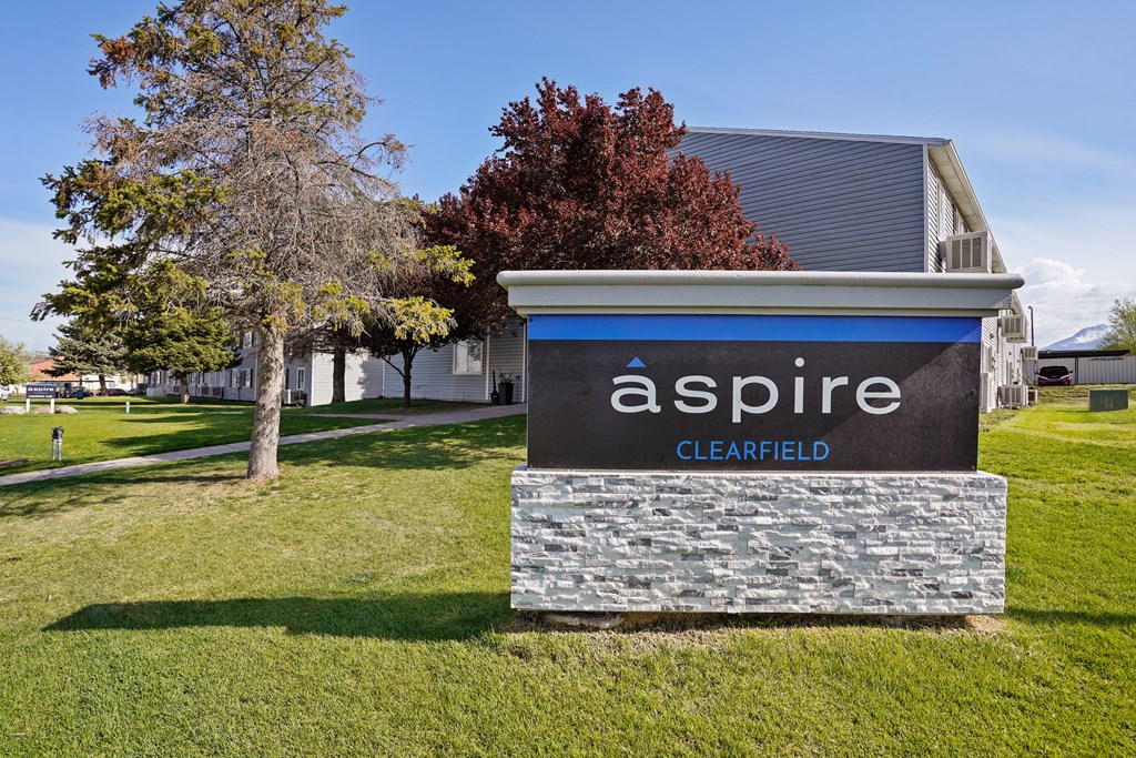A sign that says "aspire" in front of a building.