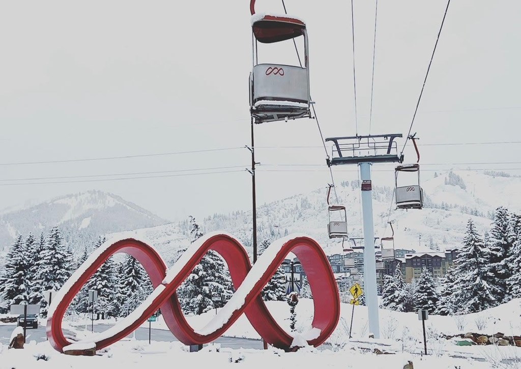 A ski lift with a large red infinity symbol in the foreground.