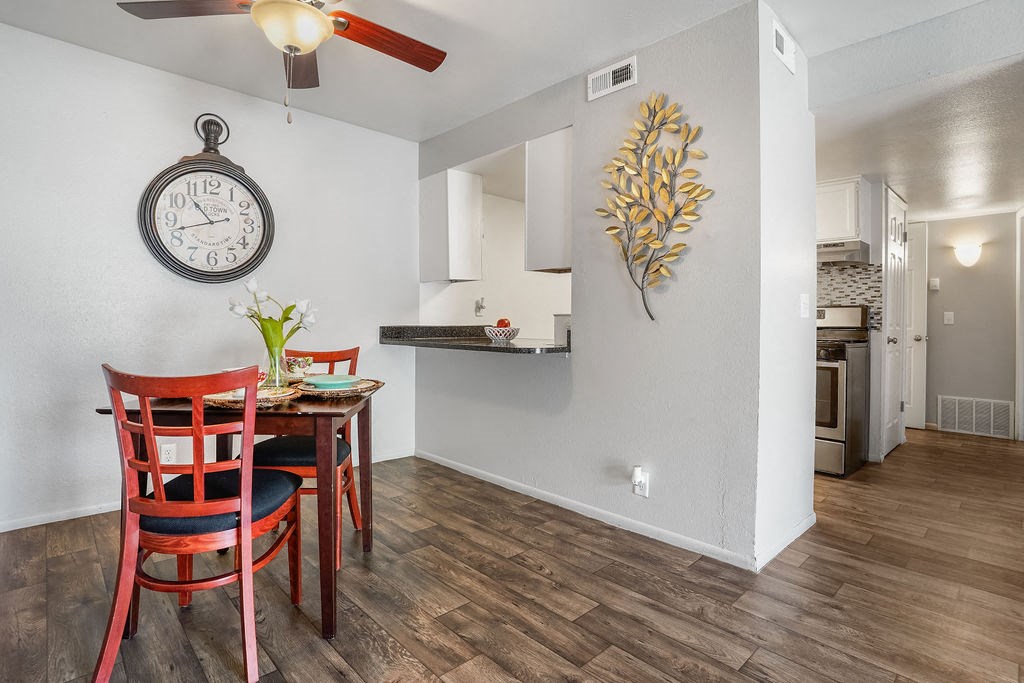a dining area with a table and chairs and a clock on the wall