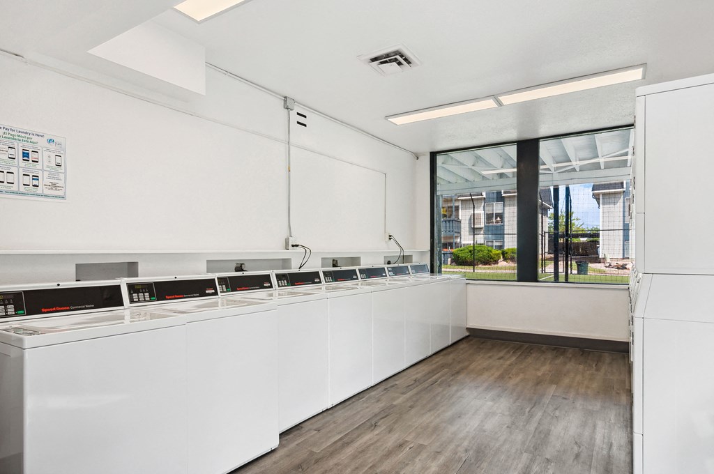 a large kitchen with white cabinets and a large window