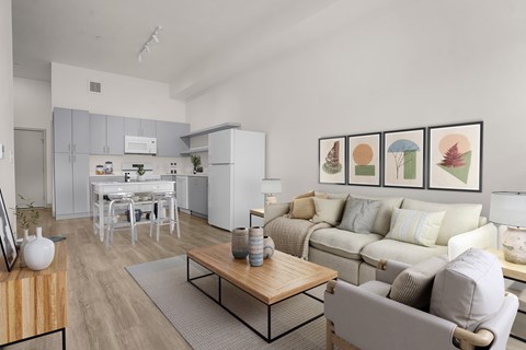 A living room with a grey couch, a coffee table, and a dining table with chairs.