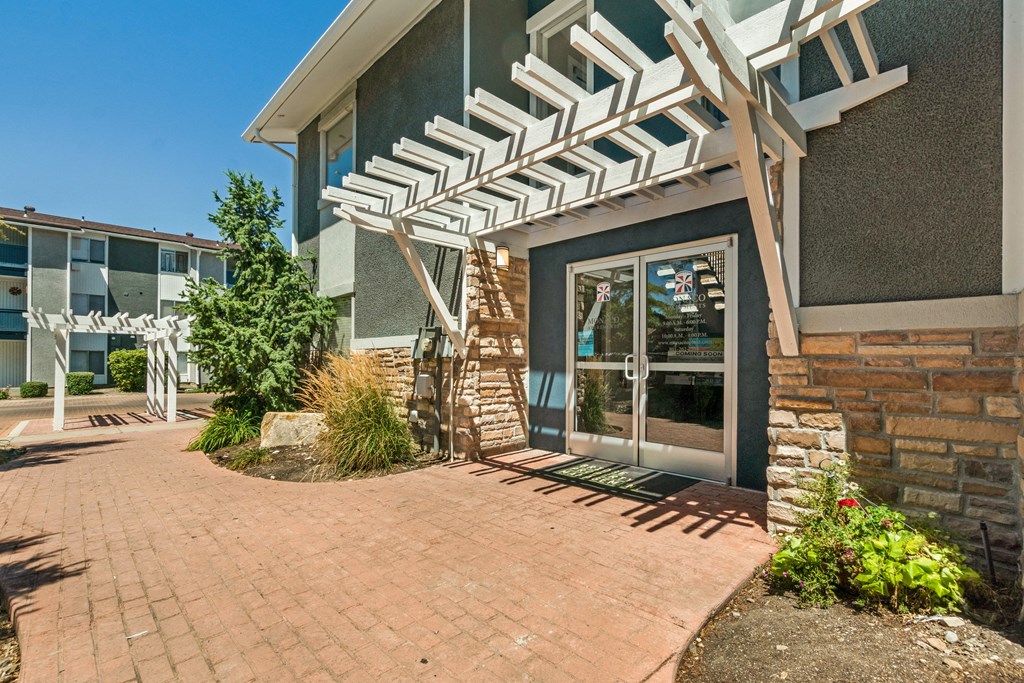 the entrance to a building with a brick sidewalk and a glass door