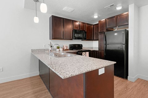 a kitchen with a granite counter top and a black refrigerator