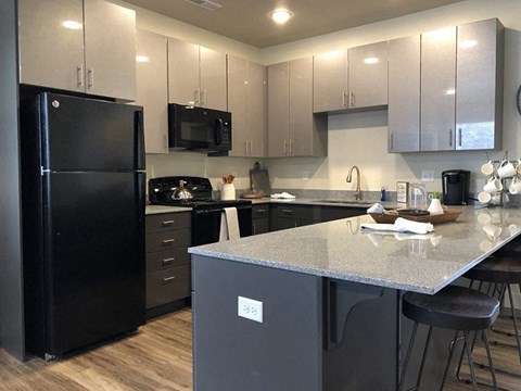 a kitchen with a counter top and a black refrigerator