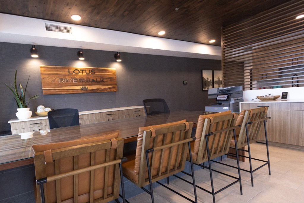 A wooden table with chairs in front of a sign that says Lotus.