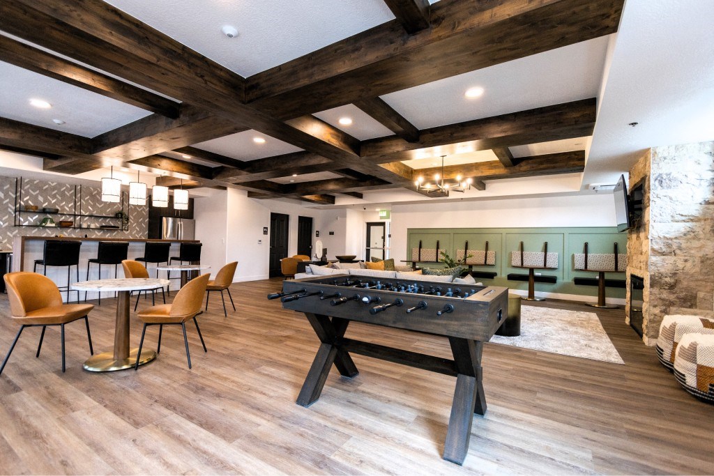 A room with a pool table and a dining table.
