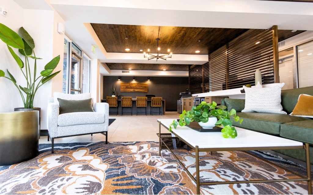 A living room with a patterned rug and a white sofa.