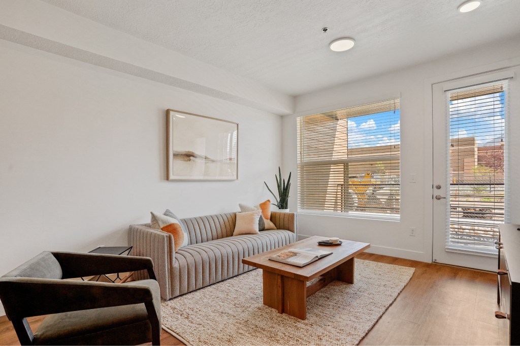 A living room with a sofa, a coffee table, and a painting on the wall.