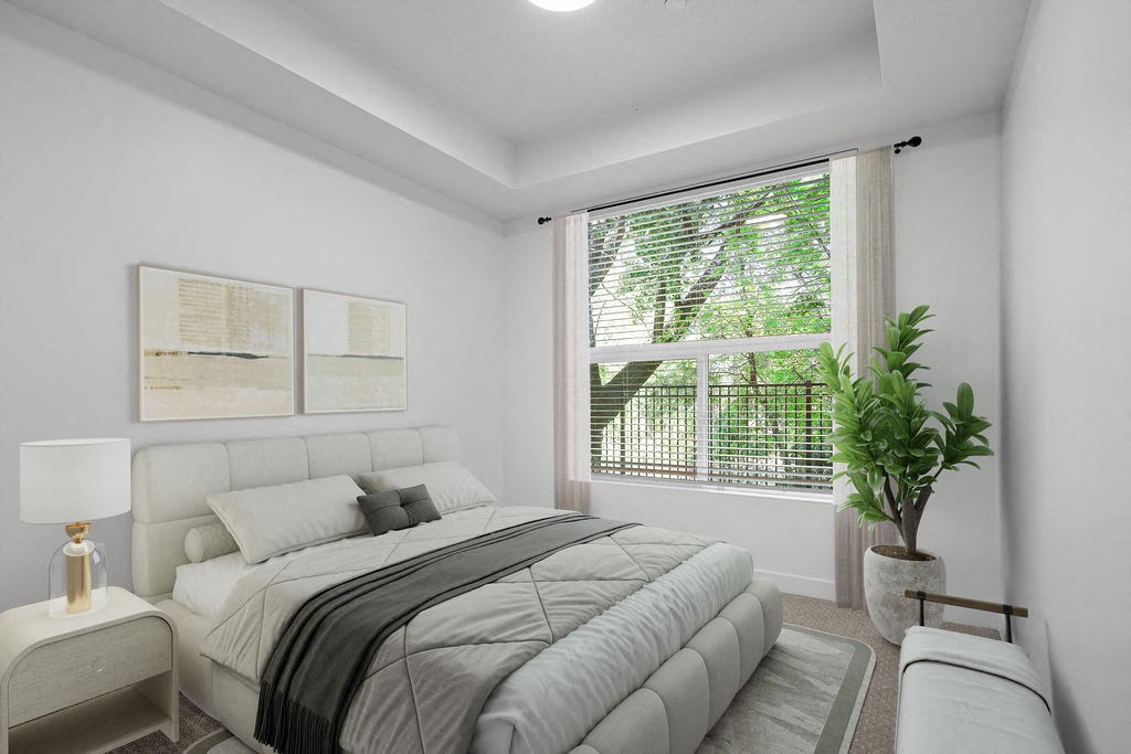 A bedroom with a large bed and a potted plant.