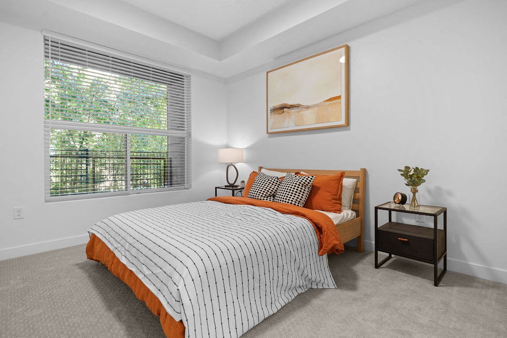 A bedroom with a large bed and a painting on the wall.