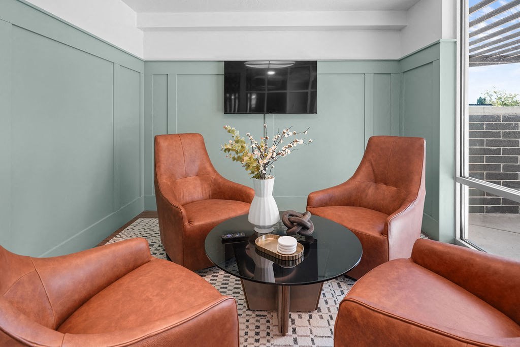 A living room with a round table and four chairs.