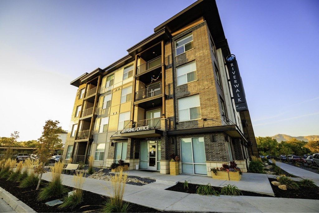 A modern apartment building with the name "Riverwalk" on the top floor.