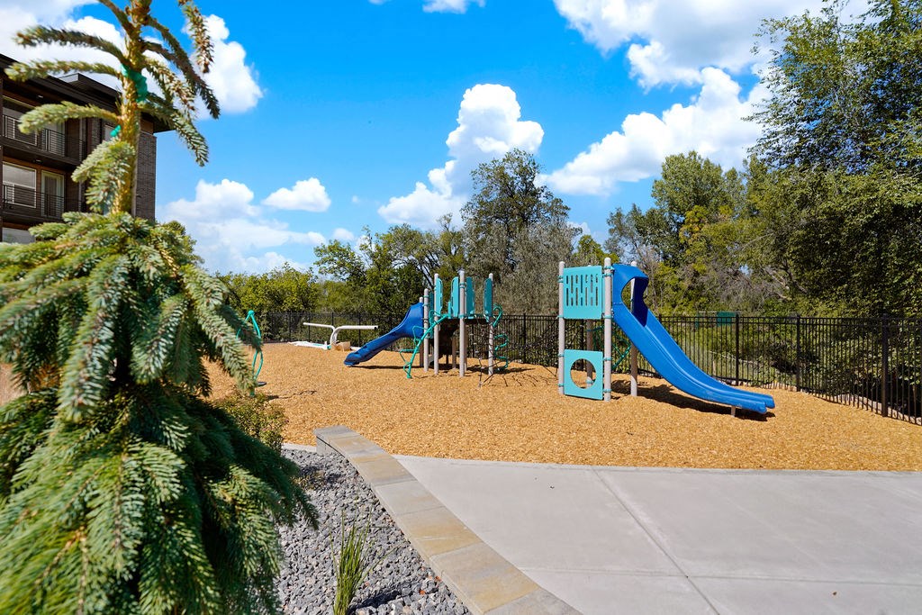 A playground with a blue slide and a green structure.