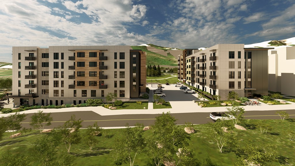 A modern apartment complex with a parking lot in front.