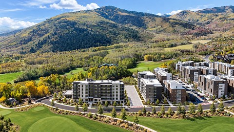 A large building complex sits in the middle of a green field.