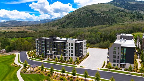 A modern building complex with a curved road in front of it.