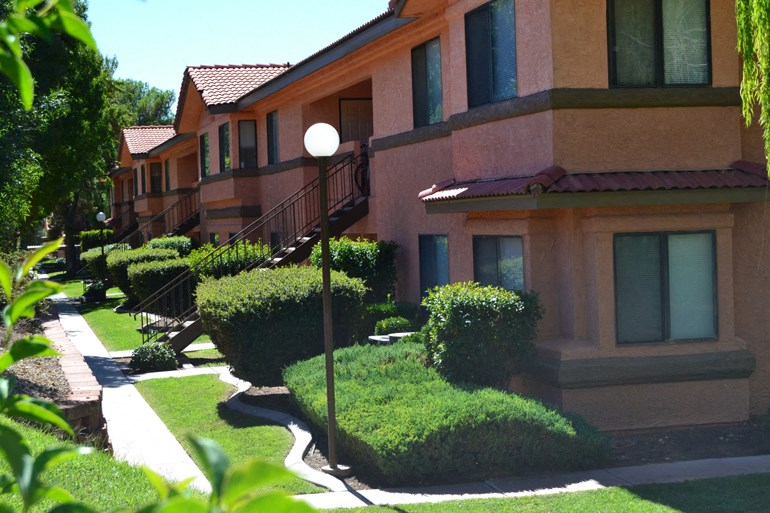 a row of houses with balconies and manicured lawns