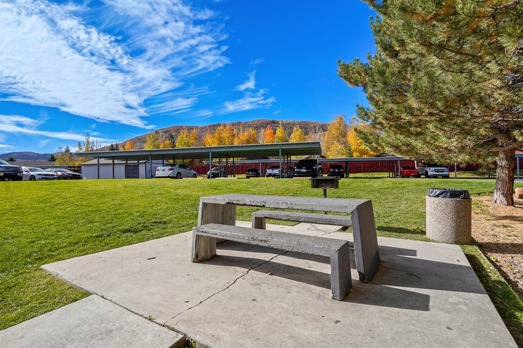 a picnic bench in a park with a building in the background