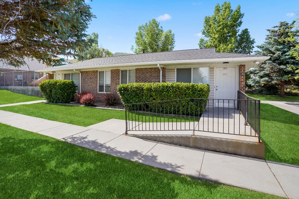 a house with a sidewalk and a fence in front of it