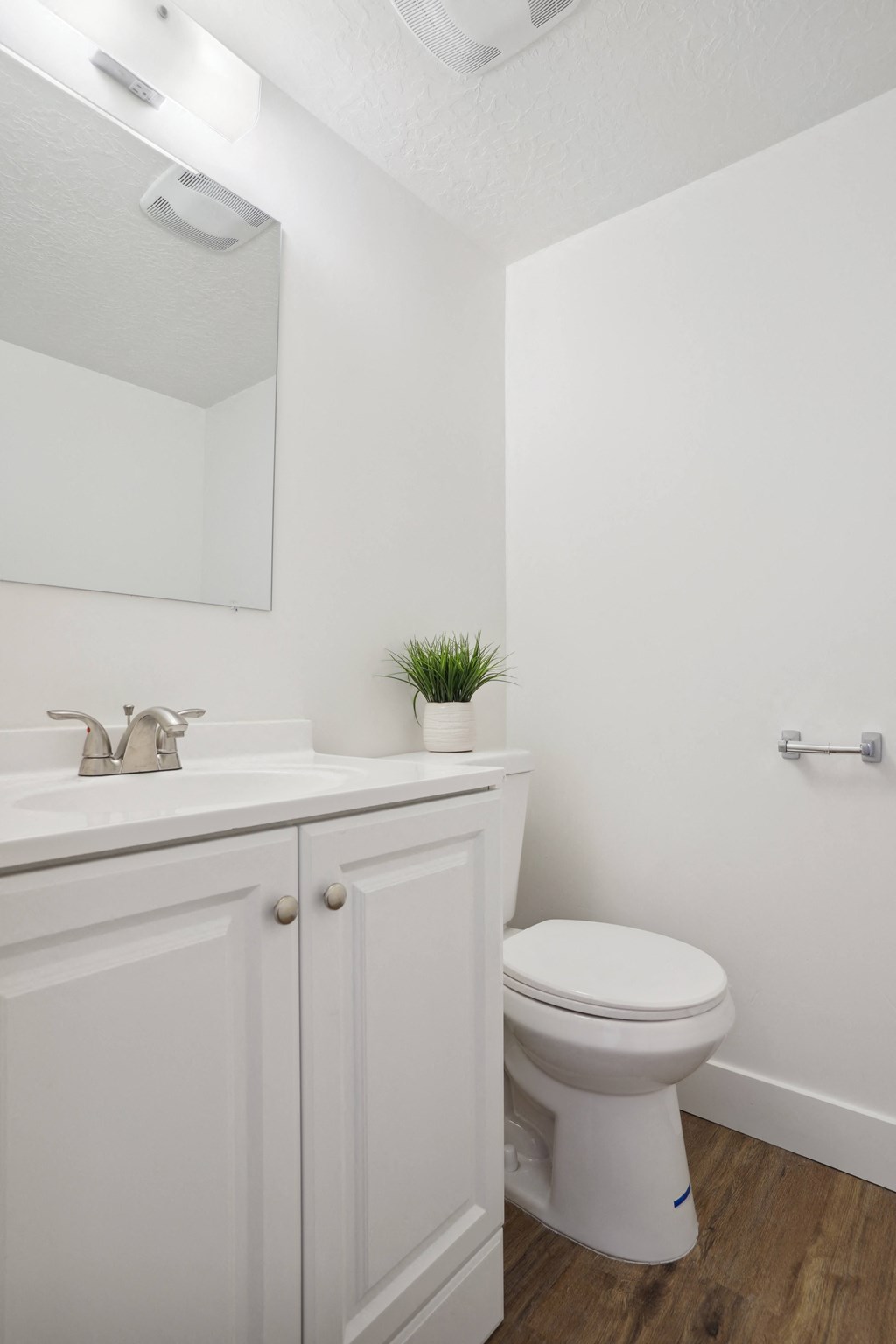 a white bathroom with a toilet and a sink