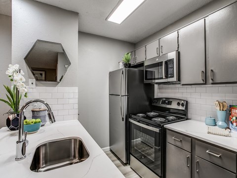 Modern kitchen with stainless steel appliances at The Melville Apartments