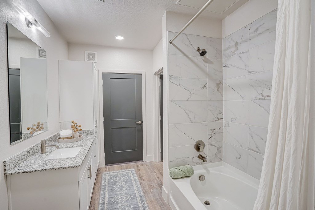a bathroom with a shower and a sink and a tub at The Mill Old Town, Lewisville, 75057