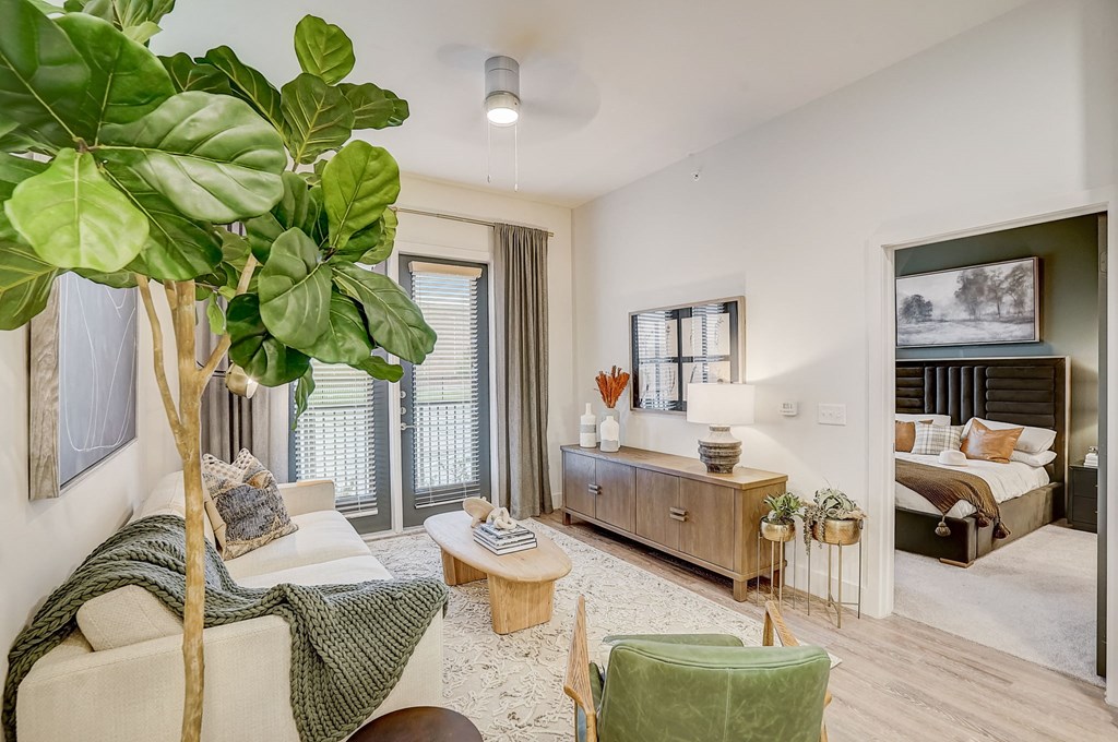 a living room with a large plant and a bedroom with a bed