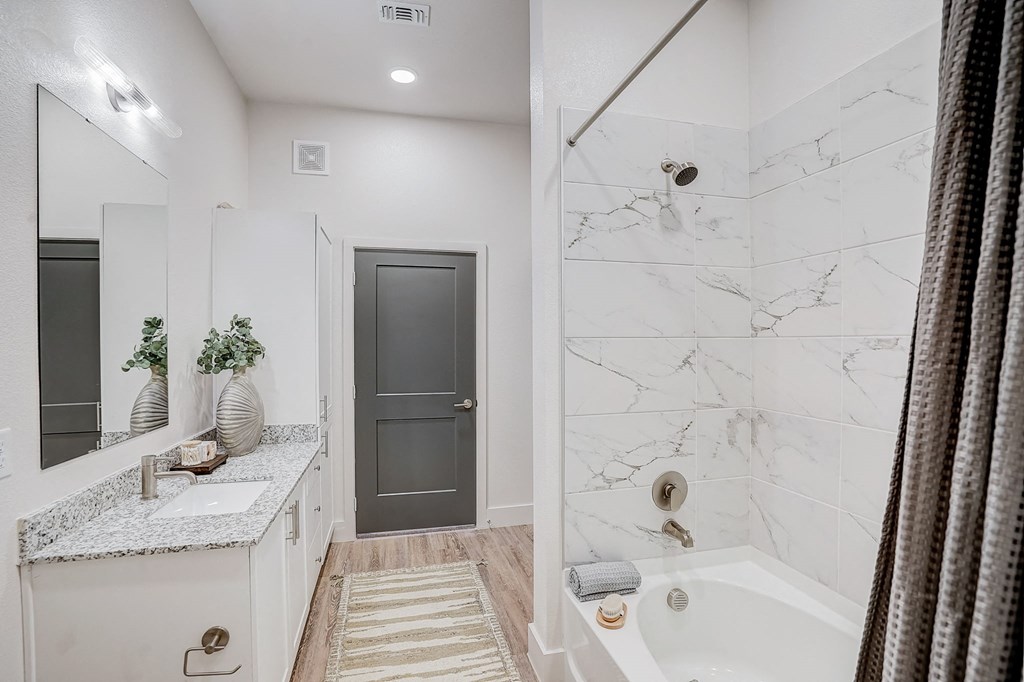 a white bathroom with a shower and a sink