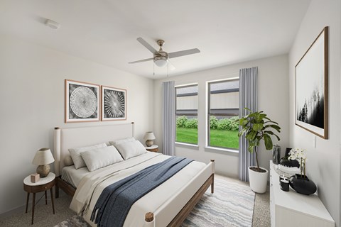 A bedroom with a large bed and a view of a green lawn outside the window.