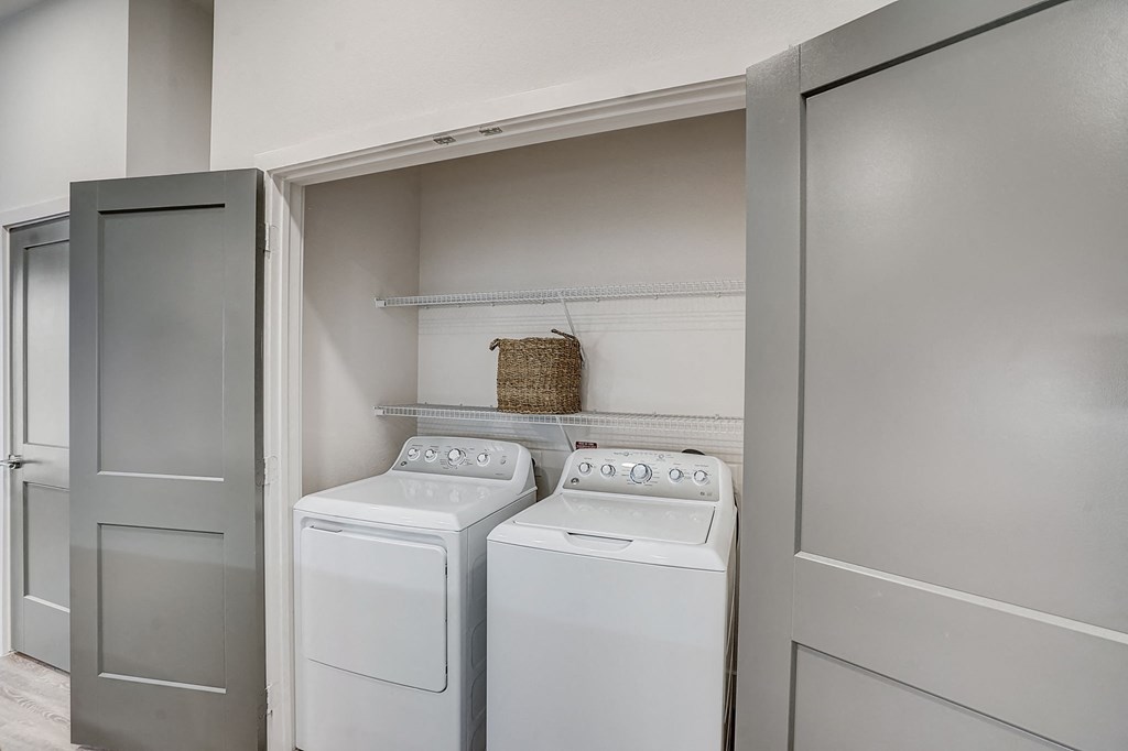 a washer and dryer in a laundry room with a door to the closet
