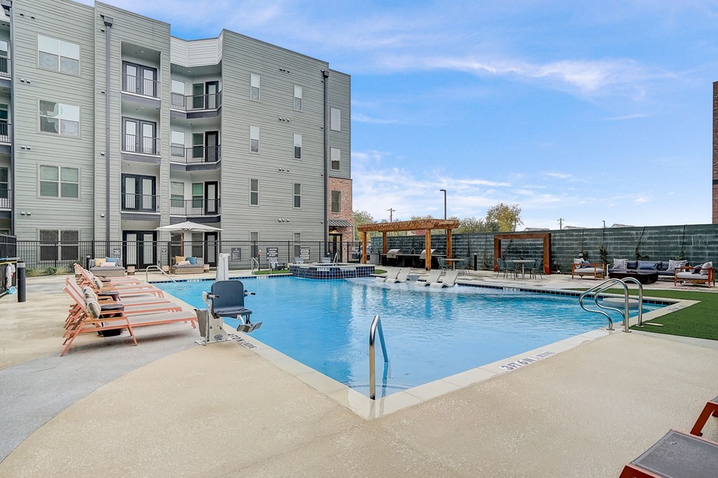 a swimming pool with a building in the background at The Mill Old Town, Lewisville, TX