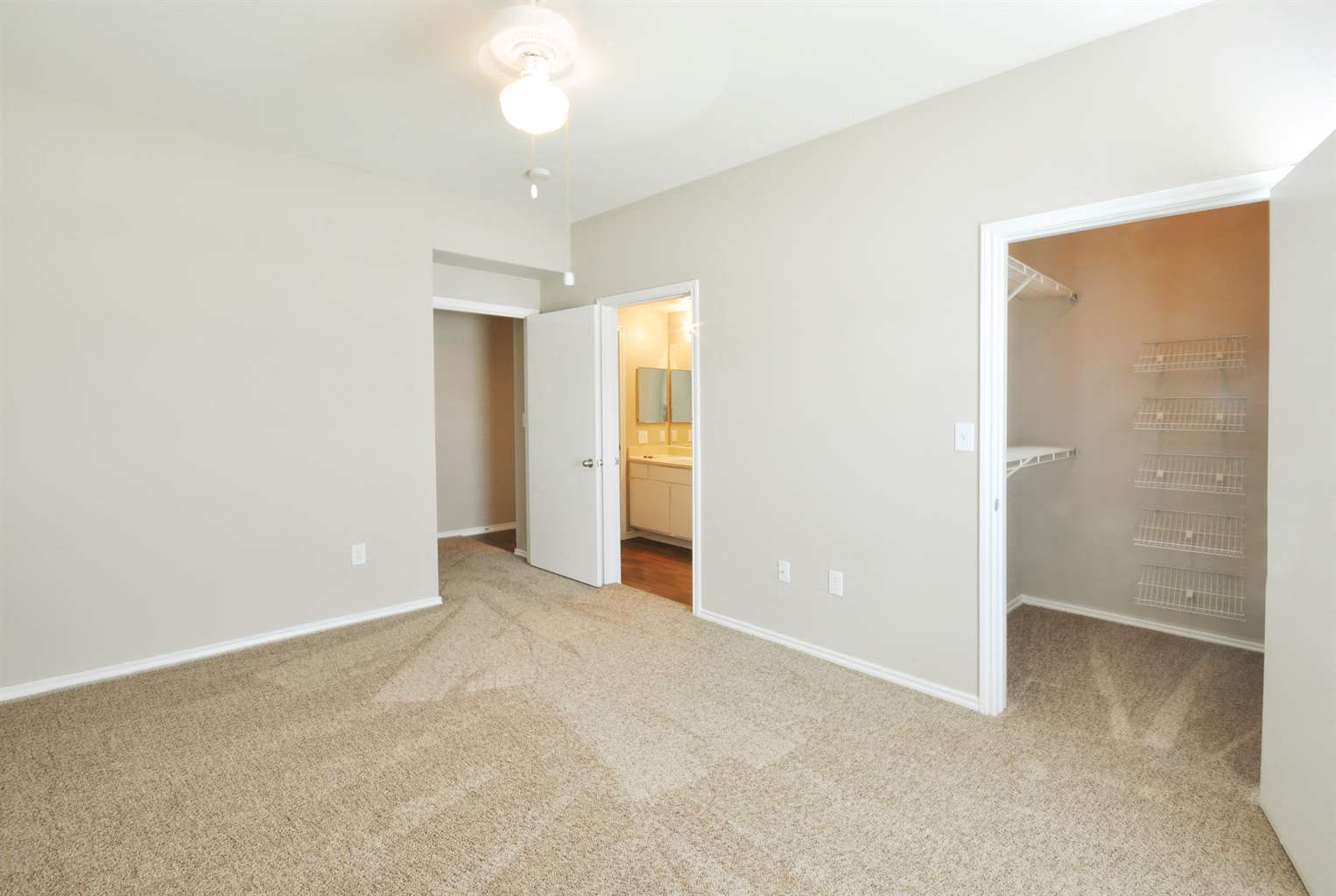 a living room with carpet and a door to a bathroom