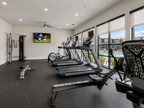 Modern fitness center with cardio equipment, strength machines, and free weights at Auberge of Tyler.