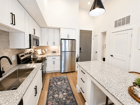 A kitchen with white cabinets and granite countertops.