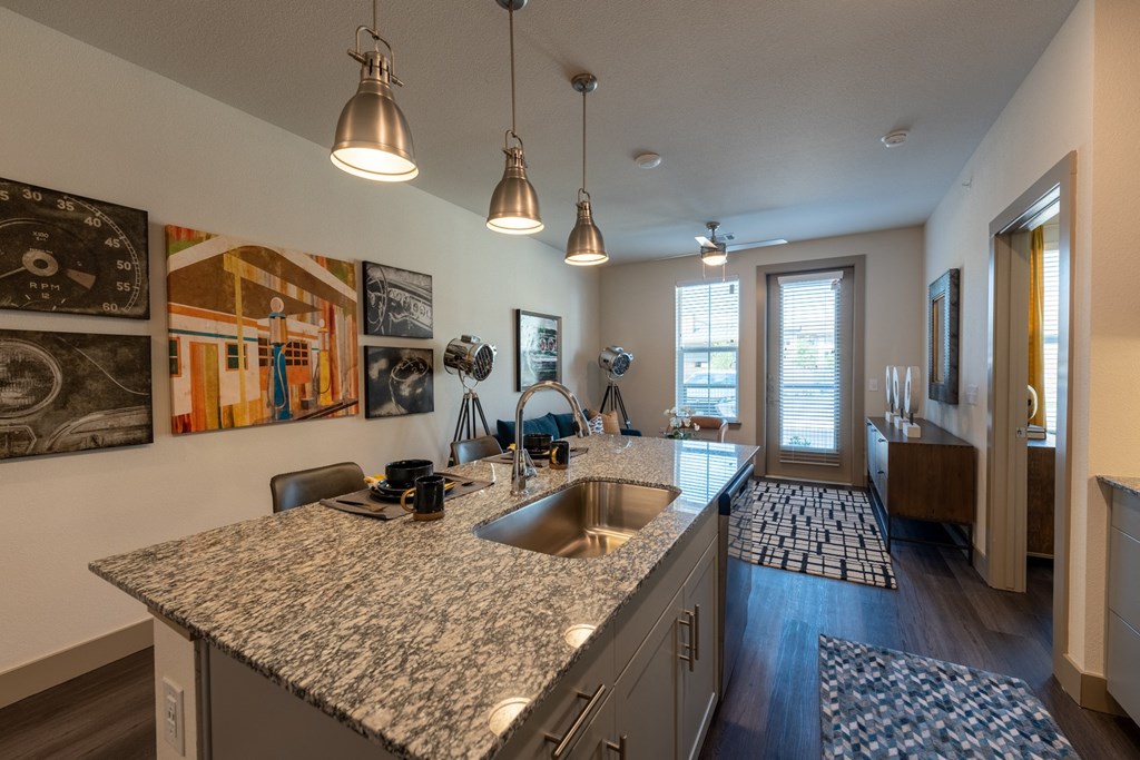 a kitchen with granite countertops and a view of the living room at One Preston Station, Celina, 75009