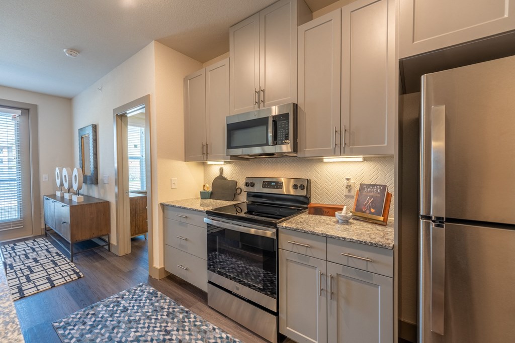 a kitchen with white cabinets and stainless steel appliances at One Preston Station, Texas