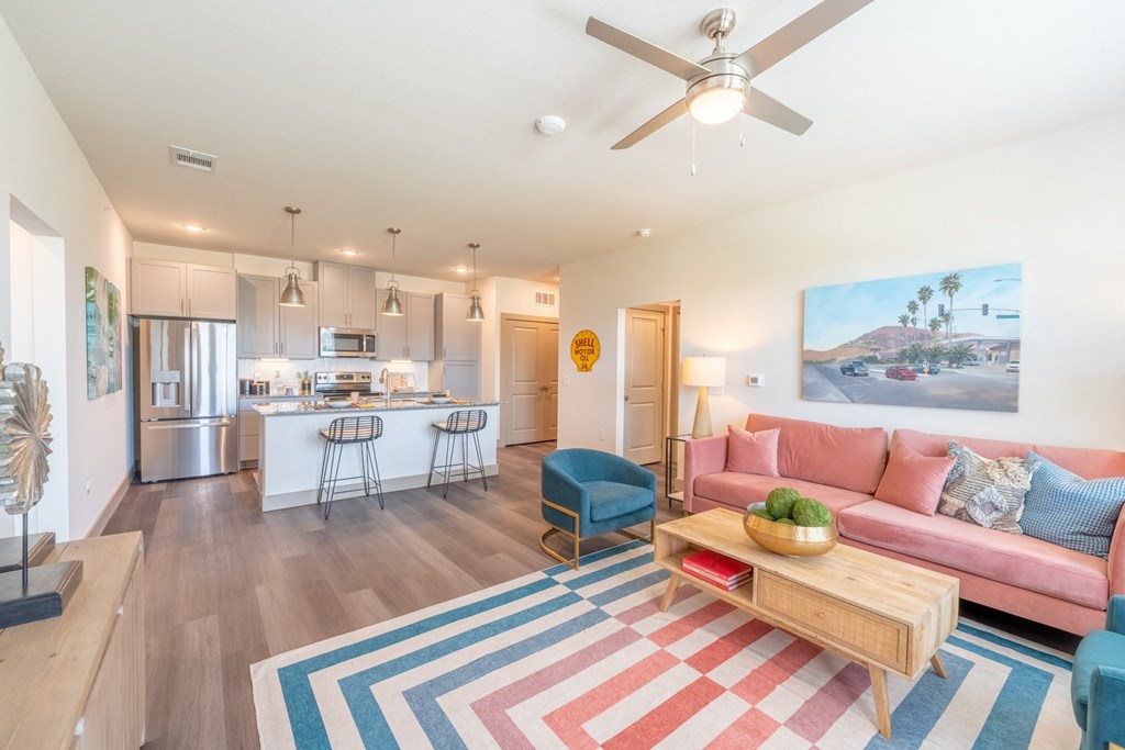 a living room with a pink couch and a blue chair at One Preston Station, Texas