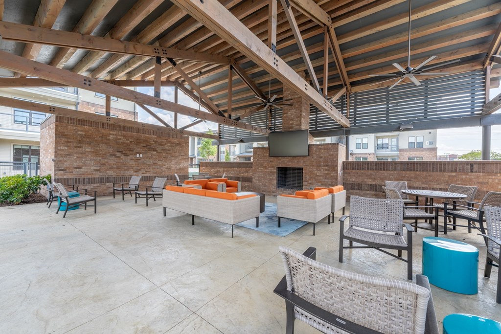 a patio with couches and chairs and a fireplace at One Preston Station, Texas, 75009
