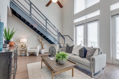 A living room with a grey couch and a wooden coffee table.