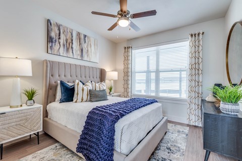 A bedroom with a large bed and a ceiling fan.