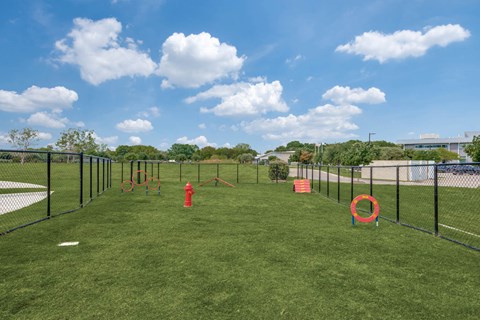A playground with a red fire hydrant and orange rings.