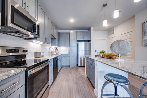 A modern kitchen with dark wood cabinets and stainless steel appliances.
