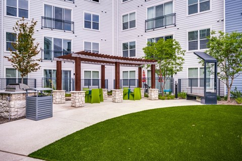 A building with a white facade and a balcony with a red pergola.
