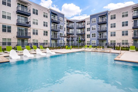 A swimming pool in front of apartment buildings.