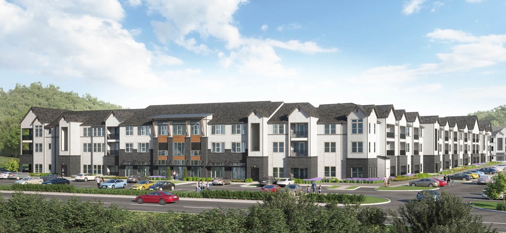 A large, modern apartment complex with multiple buildings and cars parked in the lot.